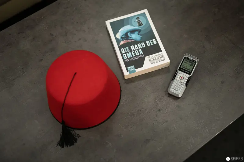 Scholarly Arrangement of Red Fez, Digital Recorder, and Literature Book