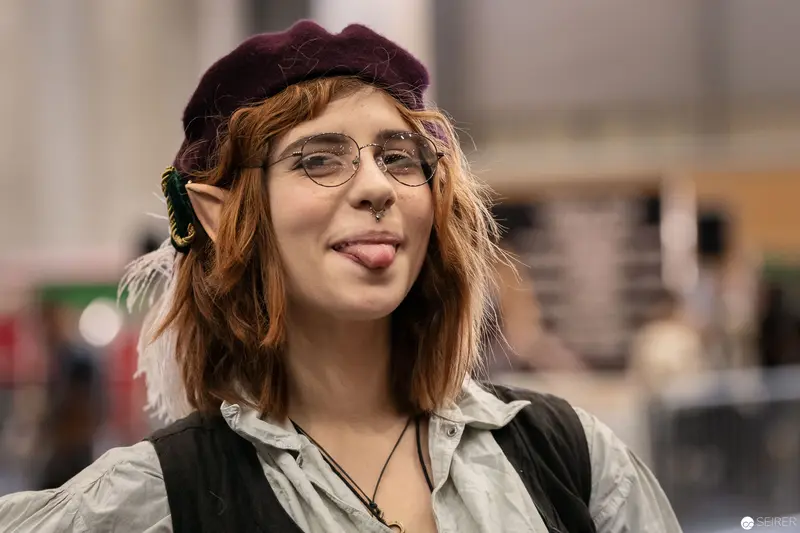 Playful Cosplay Portrait at Vienna ComicCon 2018: Tongue-Out Pose with Elf Ear Accessory