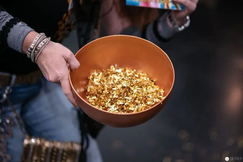 Golden Fragments: Metallic Decorative Shards in Ceramic Bowl at Event