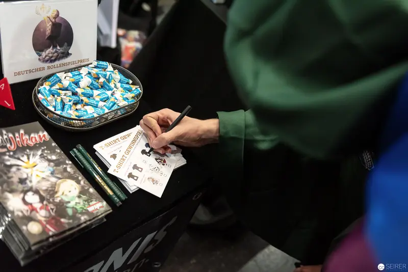Comic Con Autograph Moment: Fan Signing Memorabilia with Blue Candy Tray Nearby