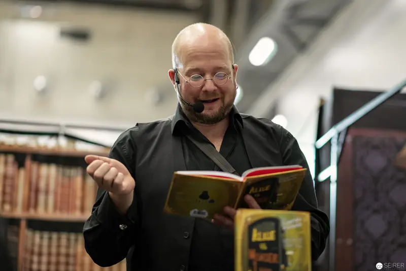 Bald Scholar Engrossed in Book amid Vintage Library Shelves at VIECC 2018