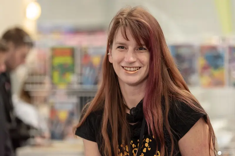 Smiling Woman in Black Top at Comic Convention Venue