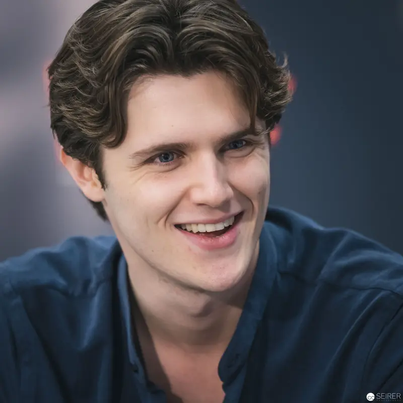Young Man in Blue Shirt Smiling Warmly During Portrait Session