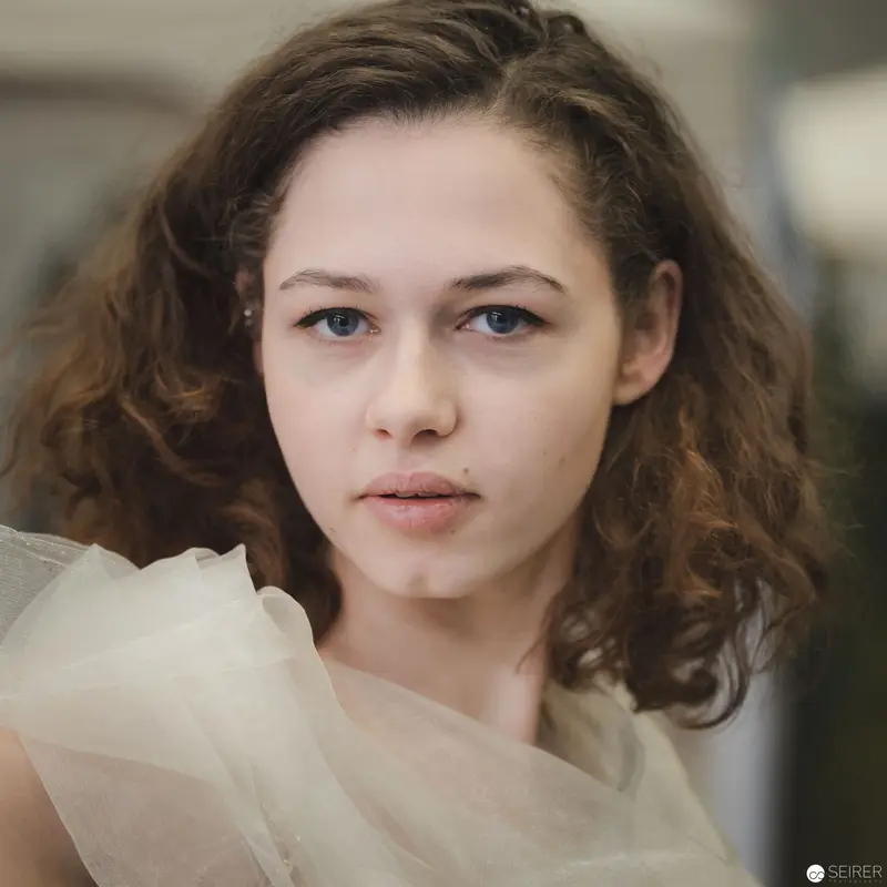 Portrait of Young Woman with Curly Hair in Soft Tulle Fabric
