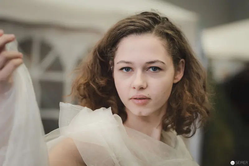 Pensive Young Woman in Translucent Fabric at Contemporary Photoshoot