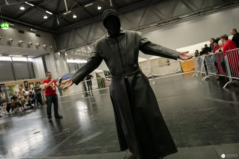Vienna ComicCon 2018: Cosplay Figure in Black Dramatic Pose with Outstretched Arms