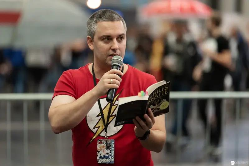 Comic Con Speaker in Red Flash T-Shirt Reading at Public Event