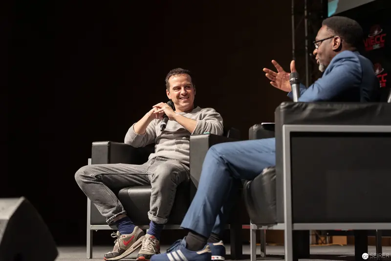 Two Speakers Engaging in Animated Discussion on Stage at Comic Convention