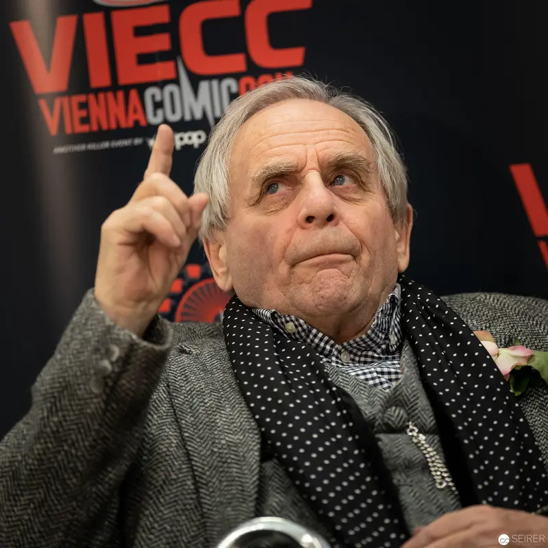 Distinguished Older Man Speaking at Vienna ComicCon 2018 with Raised Finger
