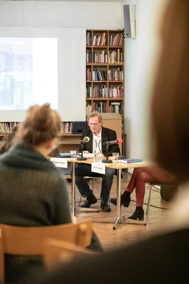Academic Panel Discussion in Institutional Library Setting with Bookshelves