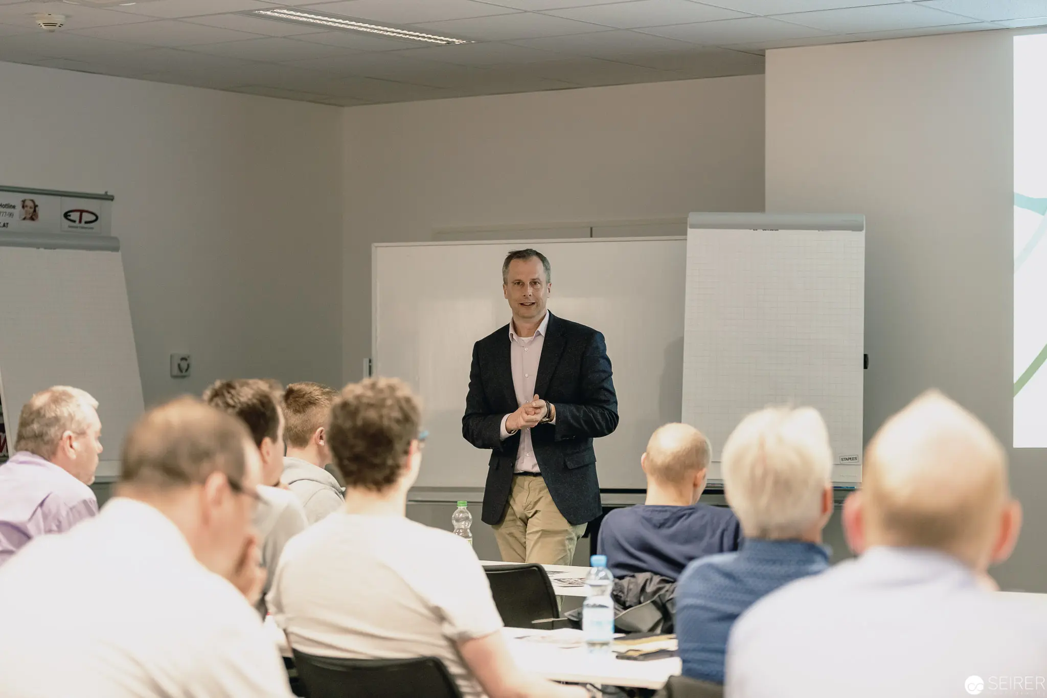 Corporate Training Session with Presenter in Black Blazer at Conference Room