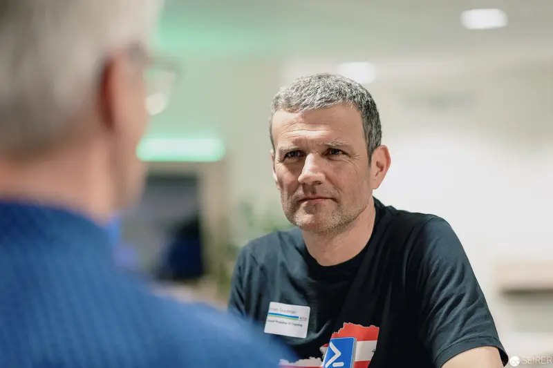 Employee in Black T-shirt During Professional Interaction at Office Setting