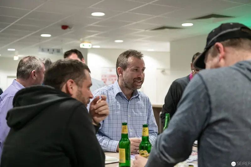 Corporate Social Gathering with Green Beer Bottles in Office Break Room