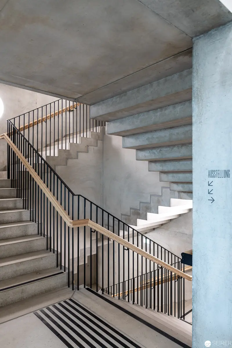 Minimalist Concrete Staircase with Geometric Railings and Architectural Lighting