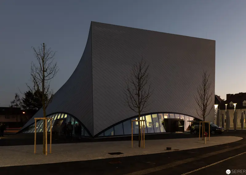 Modern Architectural Structure with Curved Façade at Twilight Urban Setting