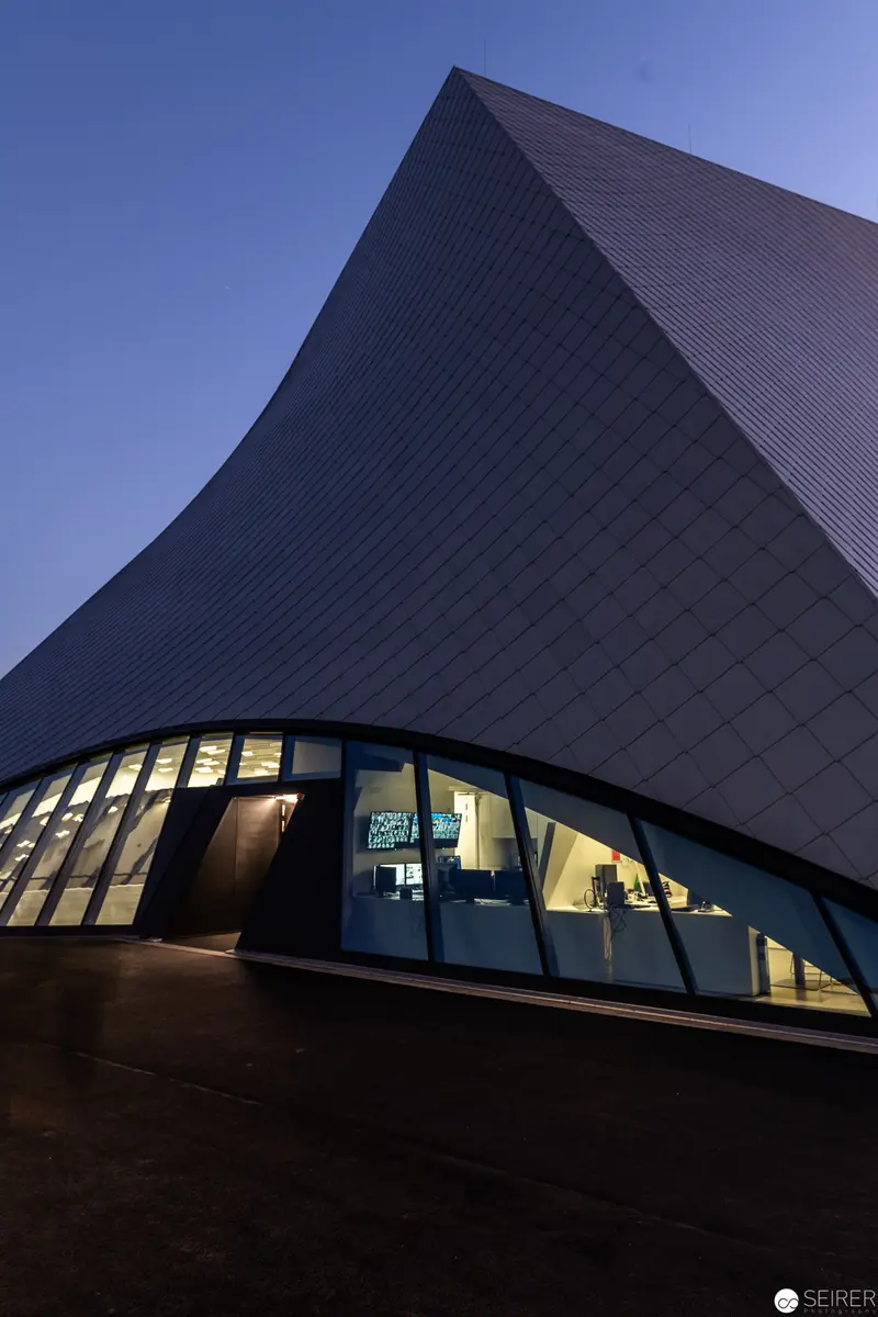 Modern Architectural Form with Illuminated Curved Glass Facade at Twilight