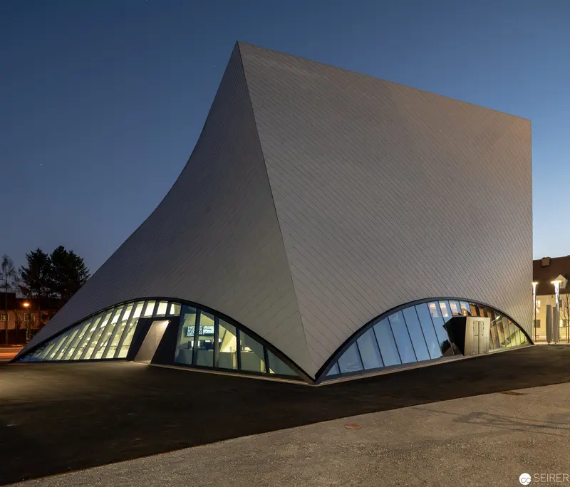 Modernist Architectural Composition with Curved Illuminated Base at Twilight