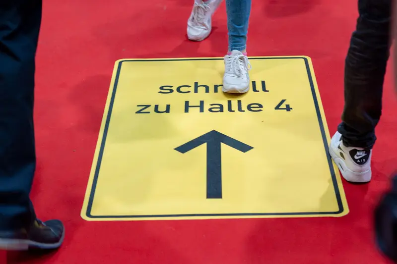 Directional Signage on Red Exhibition Floor Indicating Hall 4 Movement