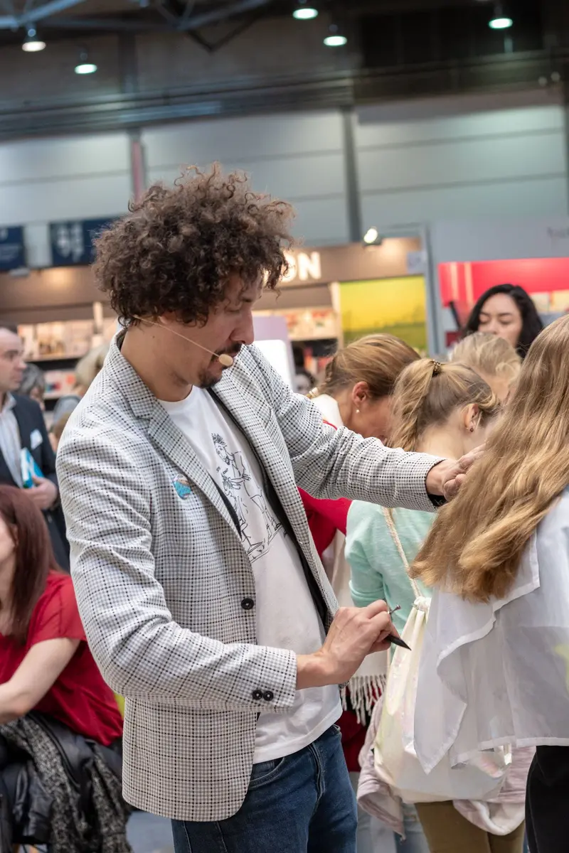 Event Professional in Checked Blazer Interacting with Attendee at Conference