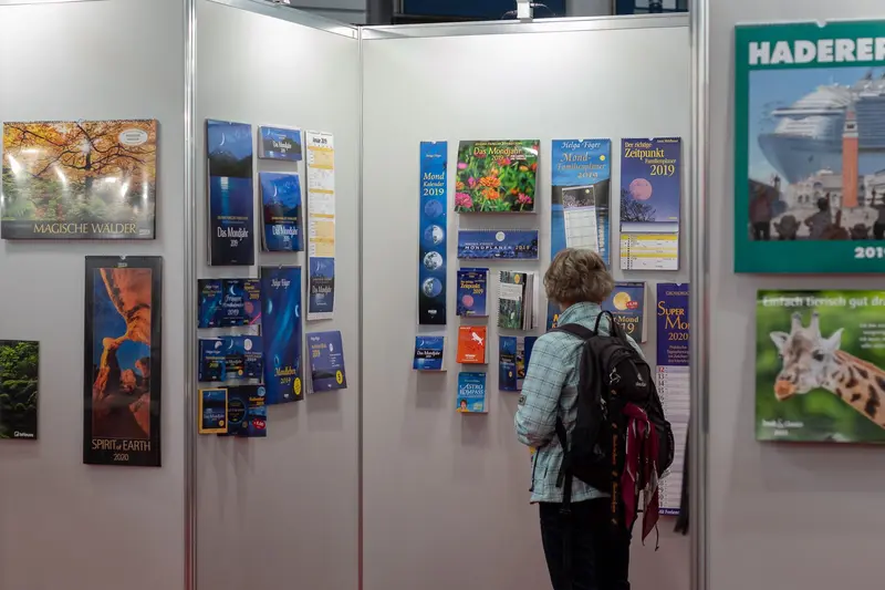 Visitor Examining Diverse Travel and Nature Posters at Exhibition Display