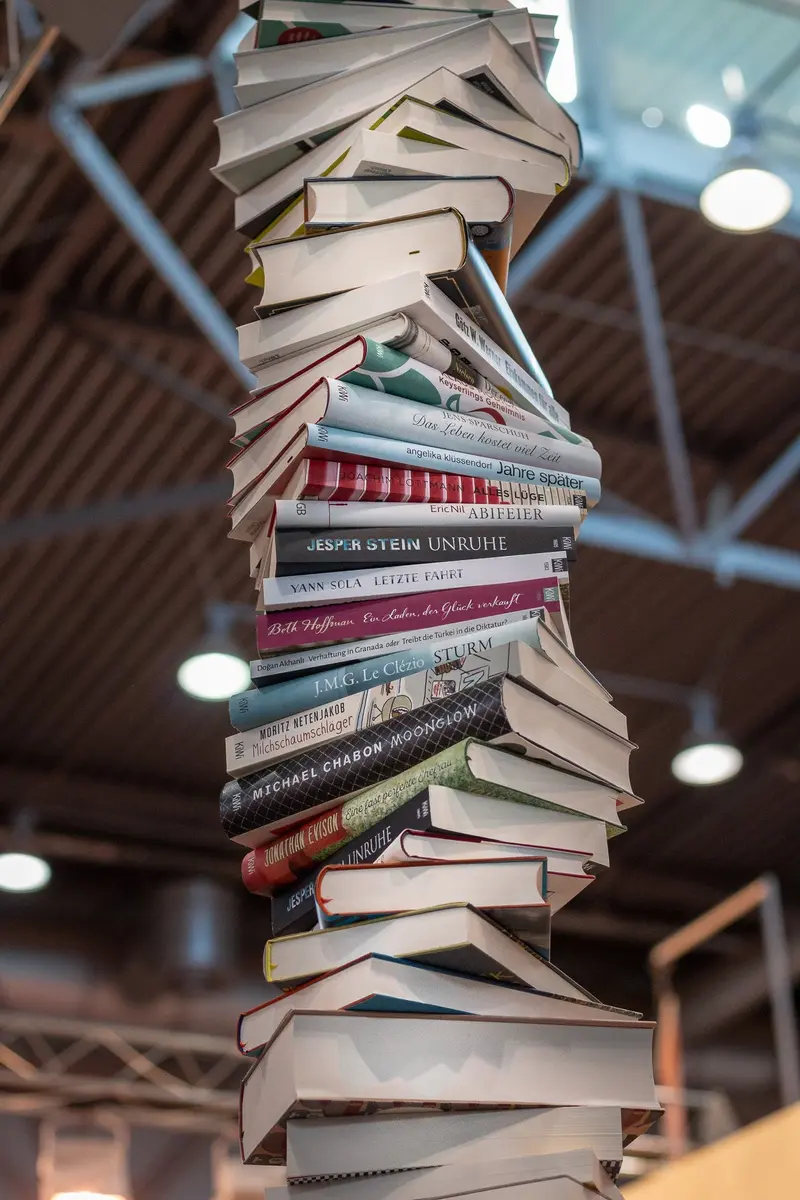 Precarious Tower of Books Balanced in Architectural Interior Space