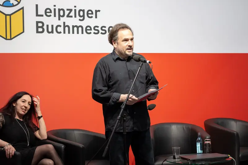 Author Speaking at Leipziger Buchmesse Literary Event in Black Attire