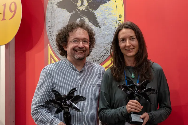 Award Recipients Posing with Black Star-Shaped Trophies at Ceremonial Event