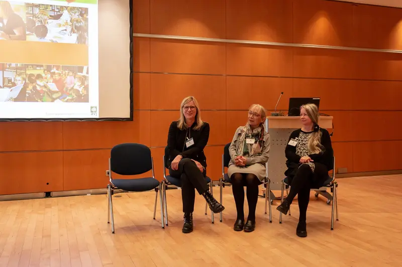 Three Women Panelists at Professional Conference Discussing Collaborative Research