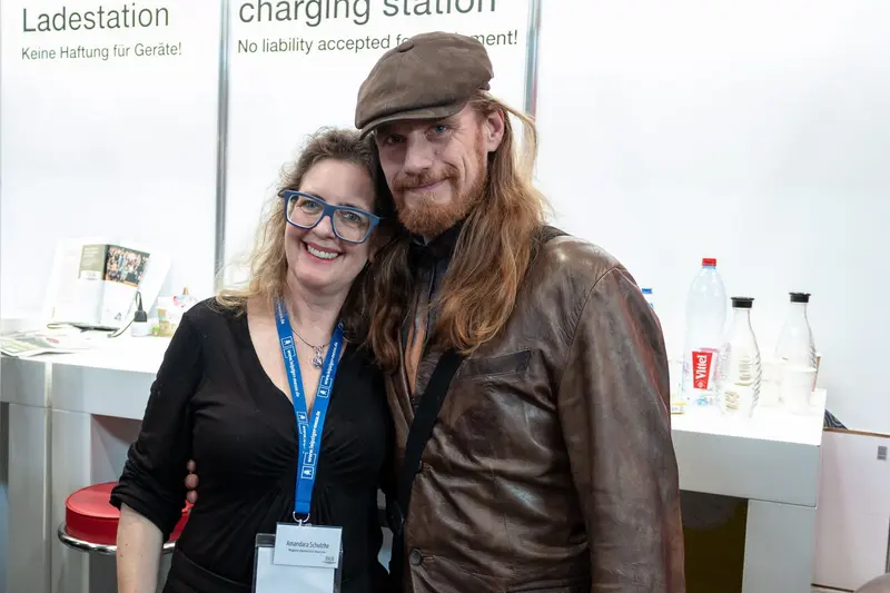 Charging Station Encounter: Two Smiling Colleagues at Professional Event