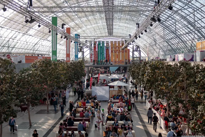 Large Indoor Exhibition Space with Hanging Banners and Indoor Trees
