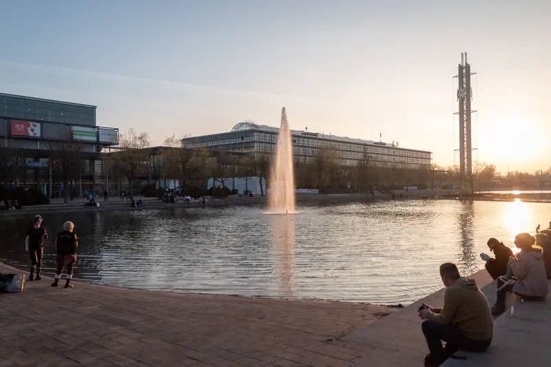 Urban Twilight: Fountain Plaza at Sunset with Silhouetted Figures