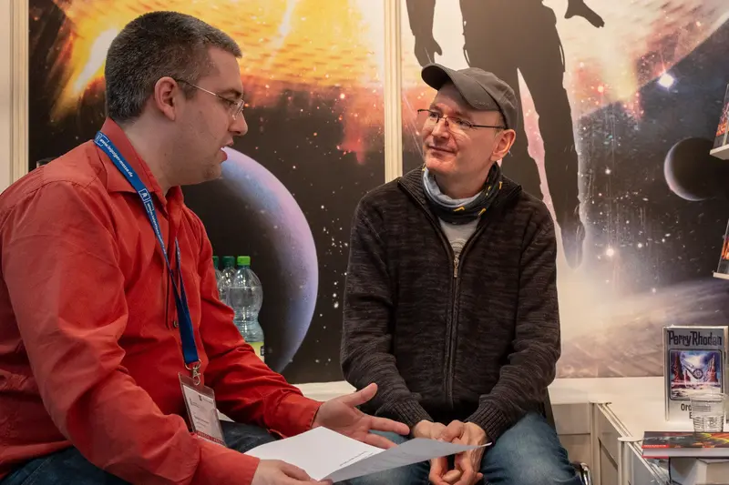 Two Men Discussing Space Imagery at Science or Media Conference Booth
