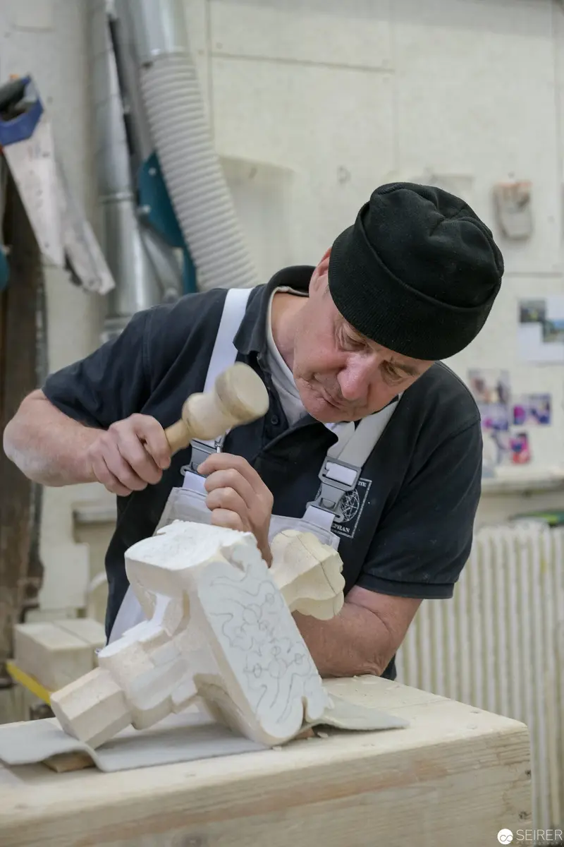 Stonemason at St. Stephan Cathedral Working Intricately with Chisel and Marble