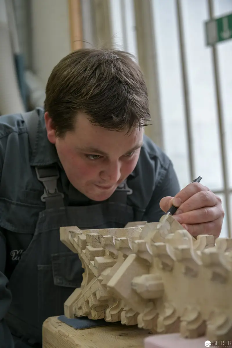 Stonemason of St. Stephan's Cathedral Carefully Sculpting Intricate Architectural Detail
