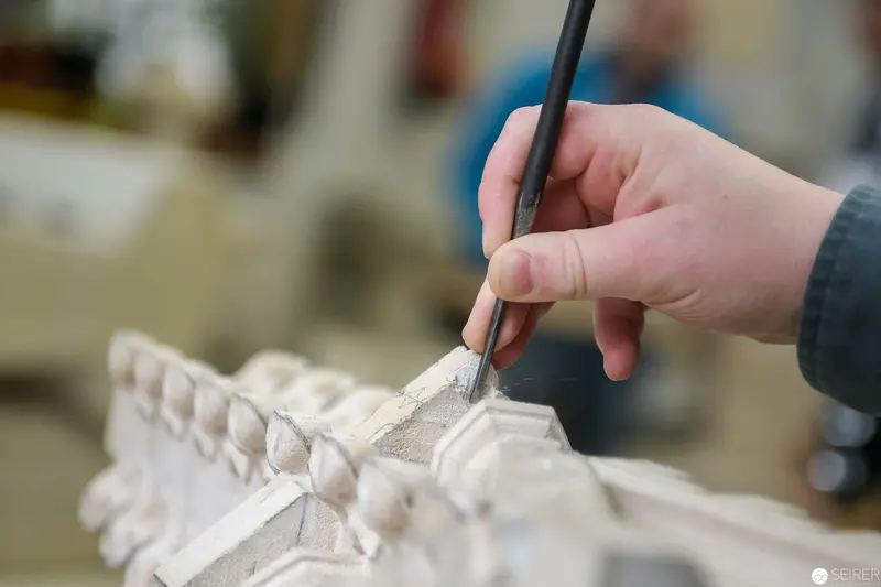 Stonemason Carefully Detailing Architectural Sculpture at St. Stephan's Cathedral Workshop