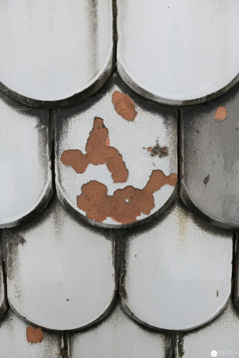 Weathered Ceramic Roof Tiles Showing Rust-Colored Degradation Patterns