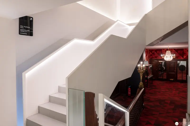 Contemporary Staircase with Dramatic Lighting and Red Interior Background
