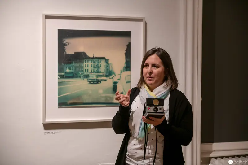 Photographer at Gallery Exhibition Examining Vintage Urban Landscape Photograph