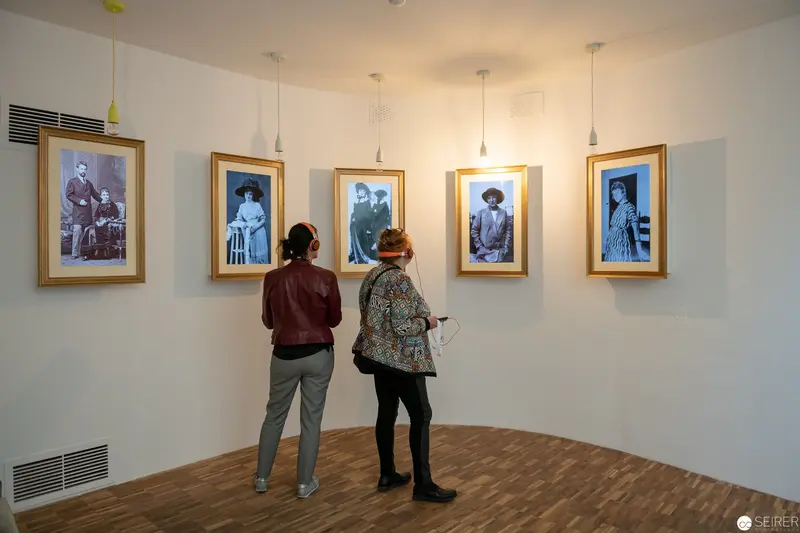 Gallery Visitors Examining Vintage Photographic Portraits in Curated Exhibition