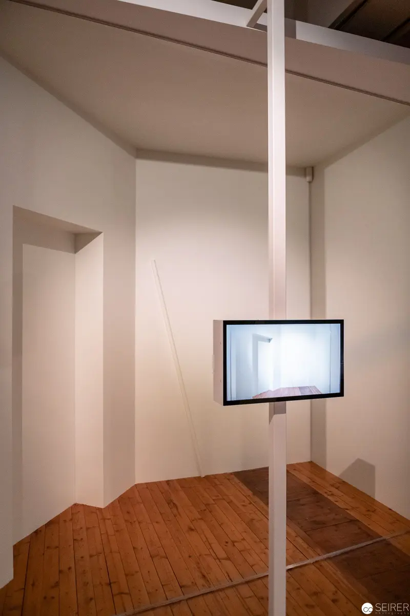 Minimalist Installation with Suspended Flat Screen on White Support Pole