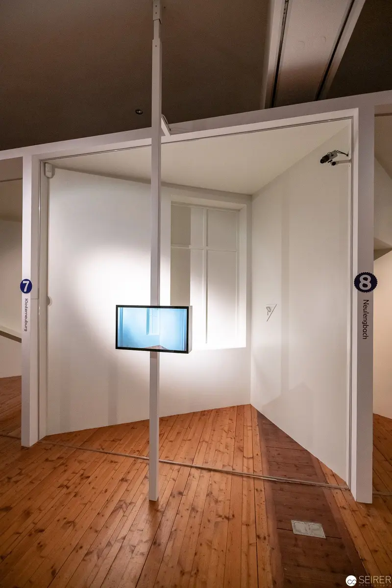 Minimalist Installation with Suspended Screen and Wooden Floor