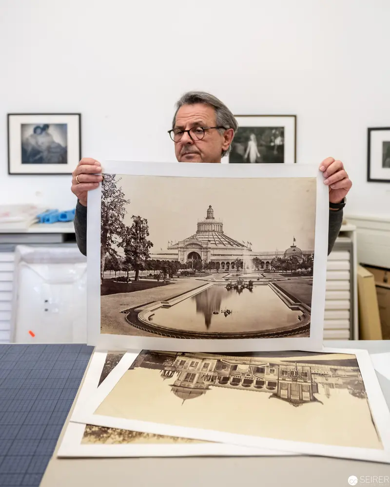 Archivist Examining Vintage Architectural Photograph in Photography Collection
