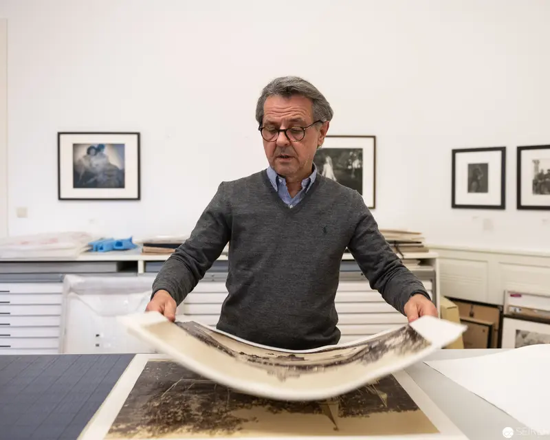 Archival Photographic Expert Examining Large-Format Print in Studio Setting