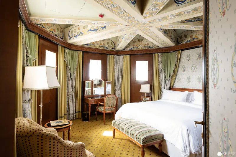 Ornate Historic Hotel Room with Decorative Ceiling and Elegant Furnishings