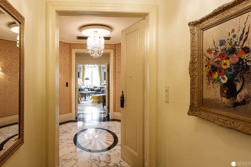 Bristol Hotel Interior: Elegant Hallway with Crystal Chandelier and Floral Artwork