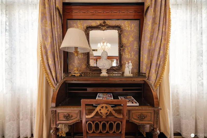 Ornate Antique Writing Desk with Baroque Mirror in Elegant Interior Setting