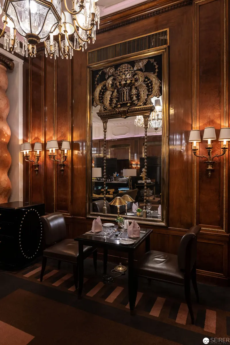 Intimate Dining Corner in Luxurious Wood-Paneled Salon with Crystal Chandelier