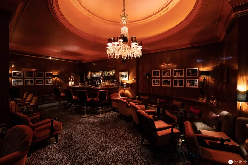 Elegant Wood-Paneled Bar with Crystal Chandelier at Hotel Bristol, Vienna