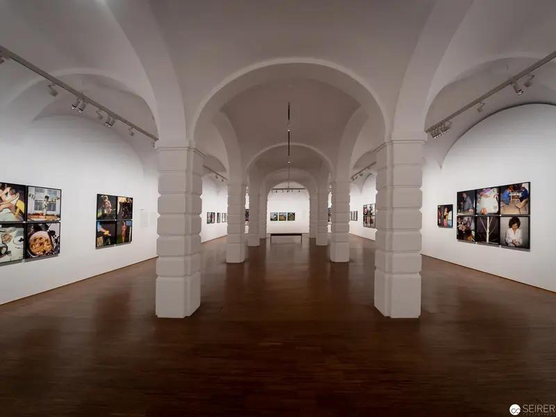 Contemporary Art Gallery Interior with Arched Architectural Columns and Photographic Exhibits