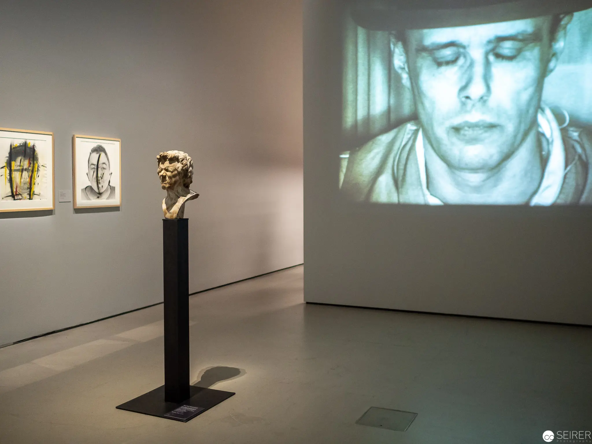 Gallery Installation with Sculpture, Projected Portrait, and Abstract Artworks